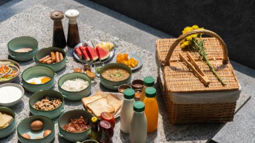 a table topped with bowls of food and a basket at Seamira House Huahin in Hua Hin