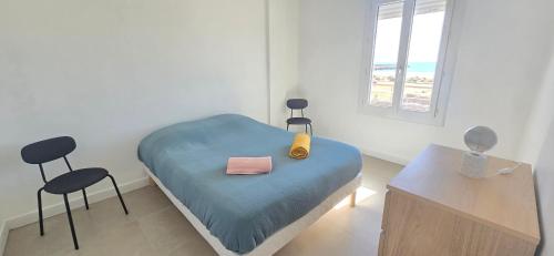 Cette chambre comprend un lit, deux chaises et une table. dans l'établissement Appartement lumineux vue mer, à Valras-Plage