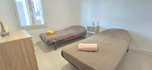 une chambre d'hôpital avec deux lits et un miroir dans l'établissement Appartement lumineux vue mer, à Valras-Plage
