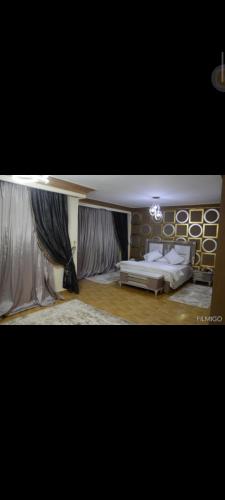 um quarto com uma cama e uma parede com cortinas em اكتوبر غرب سوميد em Cidade 6 de Outubro