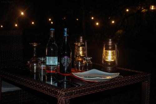 a table with bottles and glasses and lights on it at Drunken Elephant Mara in Sekenani