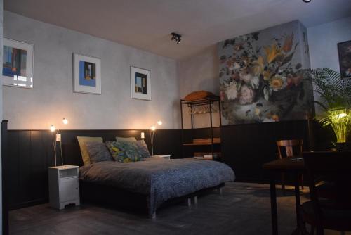 - une chambre avec un lit et une peinture murale dans l'établissement Swalmerkwartier, à Ruremonde