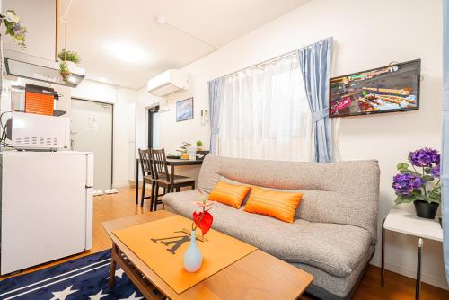 a living room with a couch and a table at KYARA HOTEL 亀戸a in Tokyo