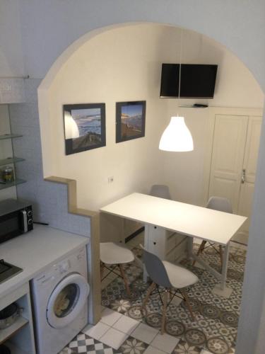 una cucina con tavolo e lavatrice di Medieval terraced house in Vieste Vecchia a Vieste