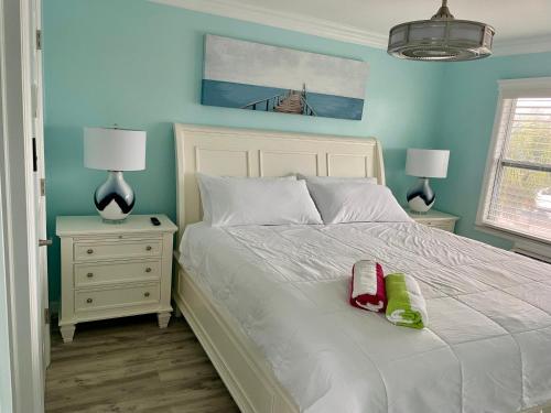 1 dormitorio con 1 cama blanca y paredes azules en Flamingo Inn en Fort Myers Beach