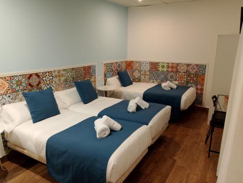 a room with three beds with towels on them at PENSION CIBELES in Córdoba