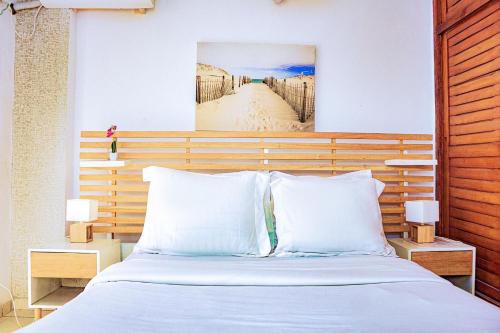 um quarto com uma cama com um quadro na parede em appartement cosy moon bonapriso em Douala