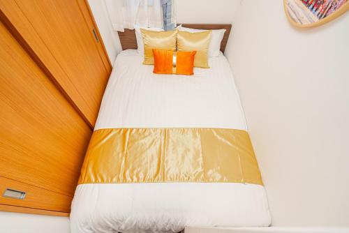 a bed with an orange pillow in a room at KYARA HOTEL 亀戸a in Tokyo