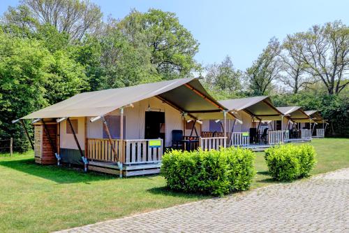 una fila de tiendas de lujo en un parque en Camping Dal van de Mosbeek, en Mander