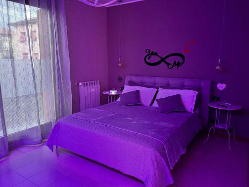 ein violettes Schlafzimmer mit einem Bett mit violetter Bettwäsche in der Unterkunft Suite Sinfonia in Bergamo