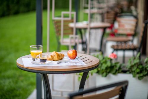 einen Tisch mit einem Apfel und einem Glas Orangensaft in der Unterkunft Arletti Hotel in Ruse