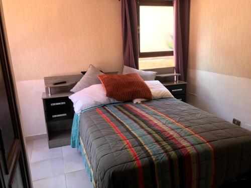 uma cama num quarto com uma janela e uma cama sidx sidx em La Casa de Los Pinos em Cochabamba