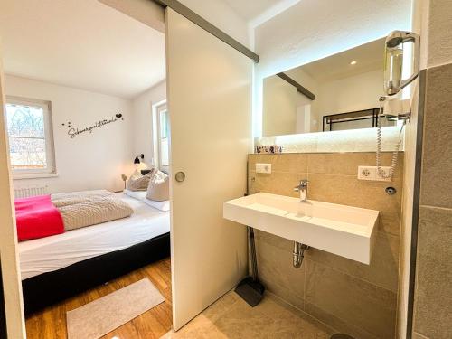 a bathroom with a sink and a bed in a room at Schwarzwald-Chalet Feldberg in Feldberg