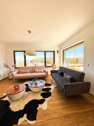a living room with two couches and a cow rug at Schwarzwald-Chalet Feldberg in Feldberg