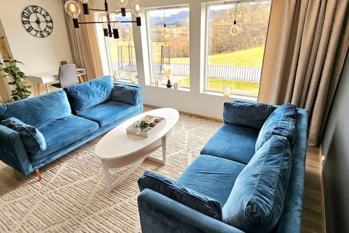 a living room with a blue couch and a table at Familie bolig med hage in Lyngdal