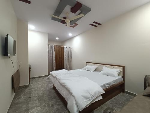 a bedroom with a large bed and a tv at RK RESIDENCY in Kothakota