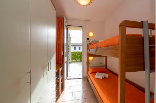 a small room with a bunk bed and a balcony at Camping Residence & Lodge Orchidea in Baveno