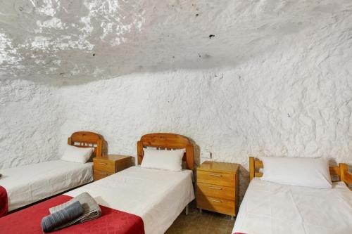 two beds in a room with white walls at Cuevas Lomo La Palma in San Bartolomé