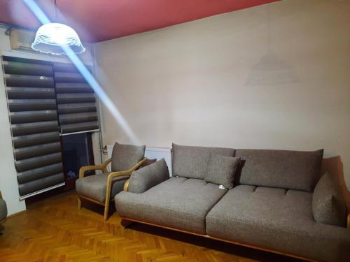 uma sala de estar com um sofá e duas cadeiras em Dardani em Pristina