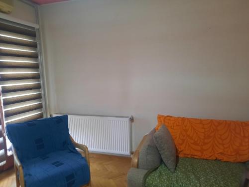 uma sala de estar com um sofá e uma cadeira em Dardani em Pristina