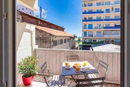 a table with two glasses of orange juice on a balcony at Cassin - Bel appartement T3 proche de la mer in Nice
