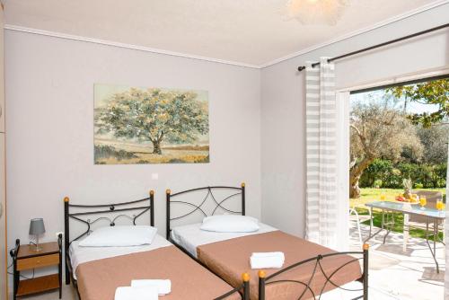 2 camas en un dormitorio con mesa y ventana en Olia Apartments S, en Ligia