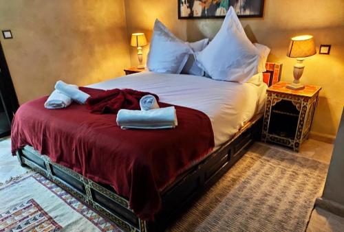 una camera da letto con un grande letto con asciugamani di Villa Ghali de Luxe & Golf a Marrakech