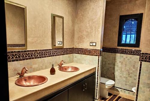 a bathroom with two sinks and a toilet at Villa Ghali de Luxe & Golf in Marrakesh