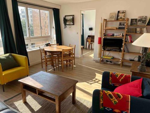 un salon avec une table et des chaises dans l'établissement 2 pièces Lumineux proche du Parc Buttes Chaumonts, à Paris
