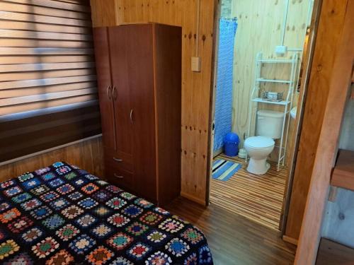 1 dormitorio con 1 cama y aseo en una habitación en Casa, central a orilla de playa en Puerto Williams