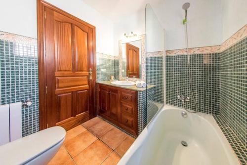 a bathroom with a tub and a toilet and a sink at 4 bedrooms villa with private pool terrace and wifi at Sant Josep de sa Talaia 2 km away from the beach in Sant Jordi