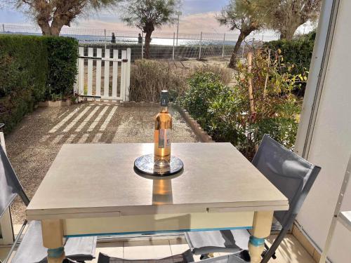 - une bouteille de vin assise sur une table sur une terrasse dans l'établissement Studio climatisé en bord de mer avec terrasse et parking privé - FR-1-716-43, à La Grande Motte
