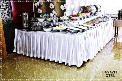 a buffet table with a white table cloth and food at Bayazıt Hotel in İskenderun