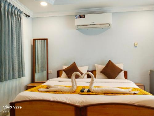 a bedroom with a bed with two swans on it at Calangute Beach Empire in Calangute