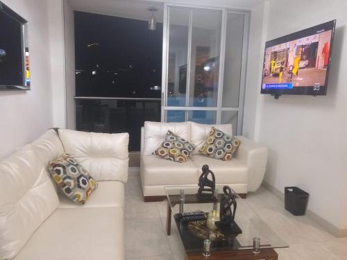 a living room with two white couches and a table at APARTAMENTO AMOBLADO SECTOR MARAYA in Pereira