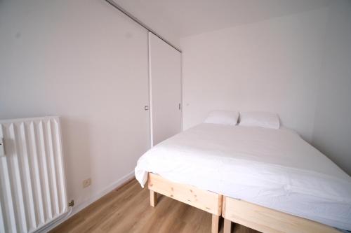a white bedroom with a bed and a radiator at Smart Appart - City Center Liege in Liège