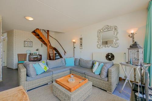 a living room with a couch and a table at Appartement Seinpost 26 - Callantsoog in Callantsoog