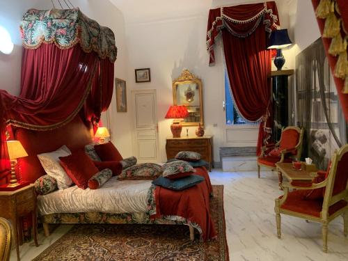a bedroom with a bed with red drapes at Petit Trianon - Appartement de Luxe in Aix-en-Provence