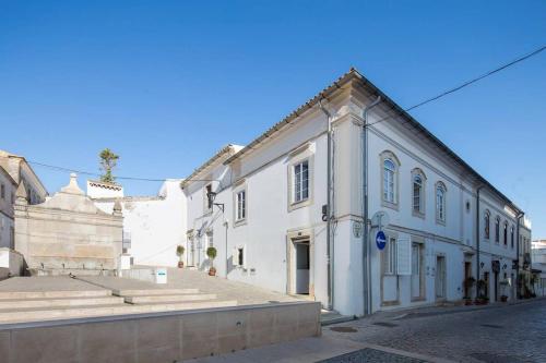 a white building on the side of a street at Bicas Velhas Studio in Loulé