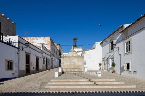 an empty street with white buildings and stairs at Bicas Velhas Studio in Loulé