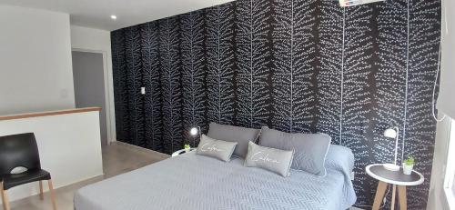 a bedroom with a bed and a black and white wall at LA MARCELINO in Patagones