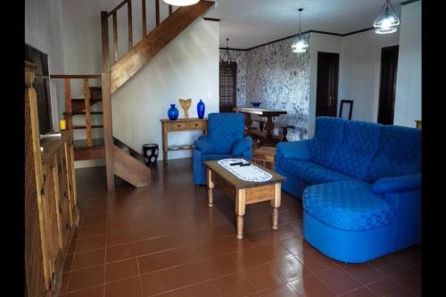 a living room with two blue couches and a table at Vila Nova in Vila Franca do Campo