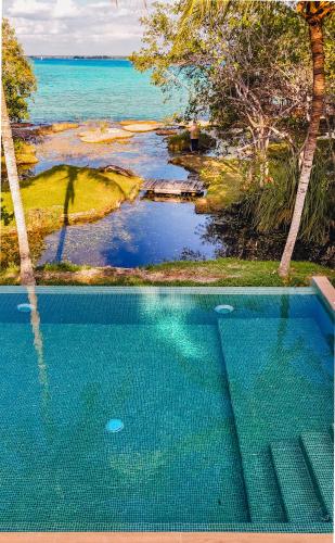 a swimming pool with a view of the ocean at Azulea Bacalar Hotel & Spa - Lagoon Front in Bacalar