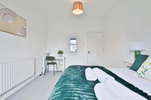 - une chambre avec un lit et une couverture verte dans l'établissement City Gem: 2-bed Flat 4 mins away from City Centre, à Cardiff