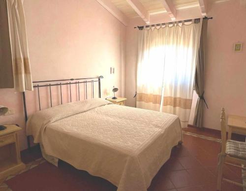 a bedroom with a large bed and a window at PortoCervo Cala Del Faro in Arzachena