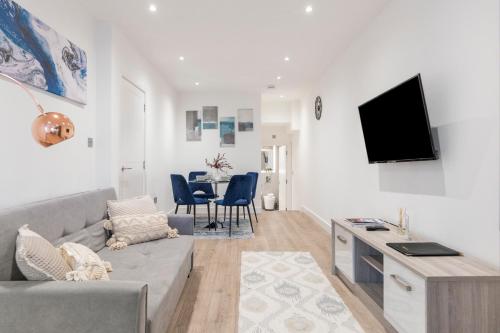 a living room with a couch and a tv on a wall at Bright and spacious Apartment - Excellent Location in London