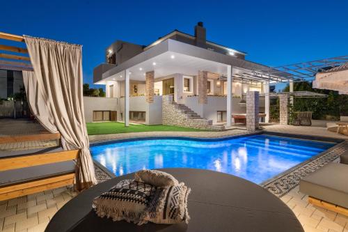 a villa with a swimming pool in front of a house at Vento Imperiale Estate in Rhodes Town