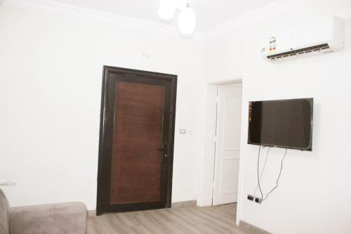 a room with a door and a television on a wall at كيان المكرونة للشقق المخدومة - Kayan Al-Makaruna Serviced Apartments in Jeddah