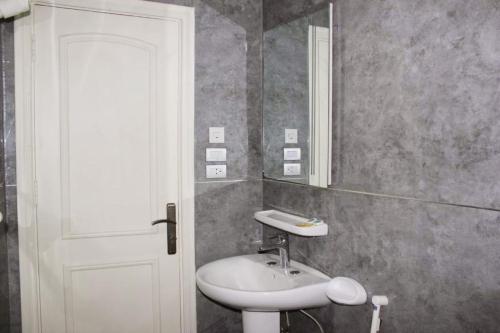 a bathroom with a sink and a mirror at كيان المكرونة للشقق المخدومة - Kayan Al-Makaruna Serviced Apartments in Jeddah