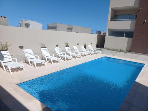 - un ensemble de chaises et une piscine dans un bâtiment dans l'établissement Sea view las grutas, à Las Grutas